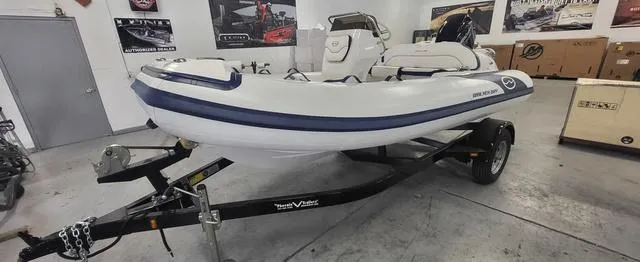 Slide: The Image of 2024 Walker Bay Venture 14 4 Seat boat on trailer in showroom. - 1