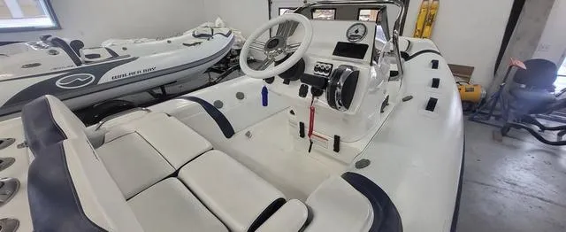 Slide: The Image of 2024 Walker Bay Venture 14 boat interior with steering wheel and seating. - 6