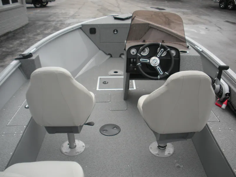 Slide: The Image of 2024 Smoker Craft Freedom 180 SC boat interior with steering console and seating. - 5