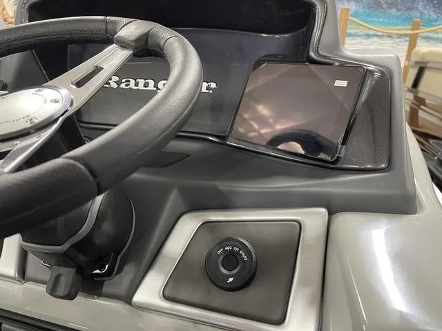 Slide: The Image of Steering wheel and dashboard of 2025 Ranger 220FC boat, featuring modern controls and tablet holder. - 17