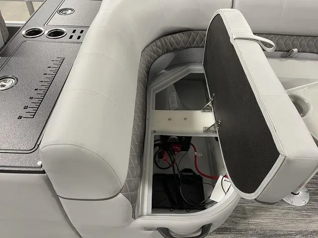 Slide: The Image of 2025 Ranger 220FC boat interior with open storage compartment and cup holders. - 24