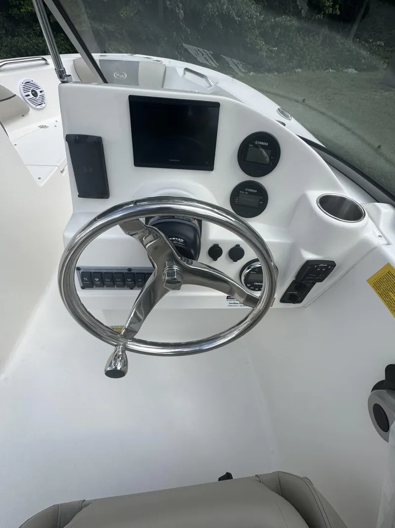 Slide: The Image of 2025 Key West 203 DFS boat dashboard with steering wheel and control panel. - 5
