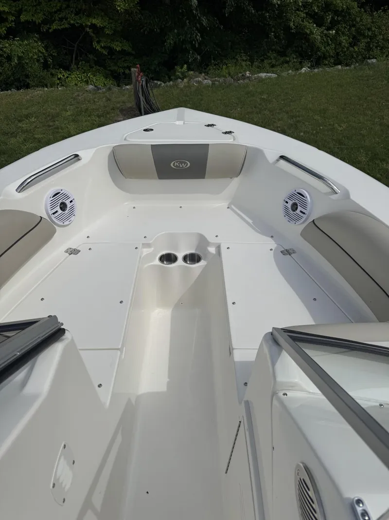 Slide: The Image of 2025 Key West 203 DFS boat interior with seating and cup holders, set against a grassy background. - 9