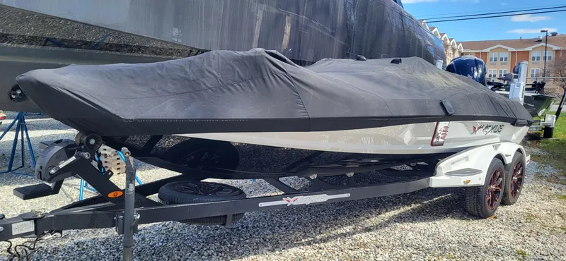 Slide: The Image of 2021 Vexus VX20 boat covered on a trailer, parked outdoors. - 14