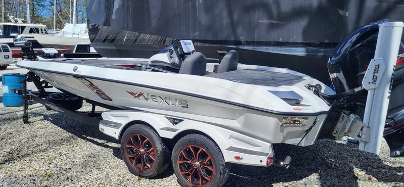 Slide: The Image of 2021 Vexus VX20 boat on trailer with red-accented wheels, parked outdoors. - 4