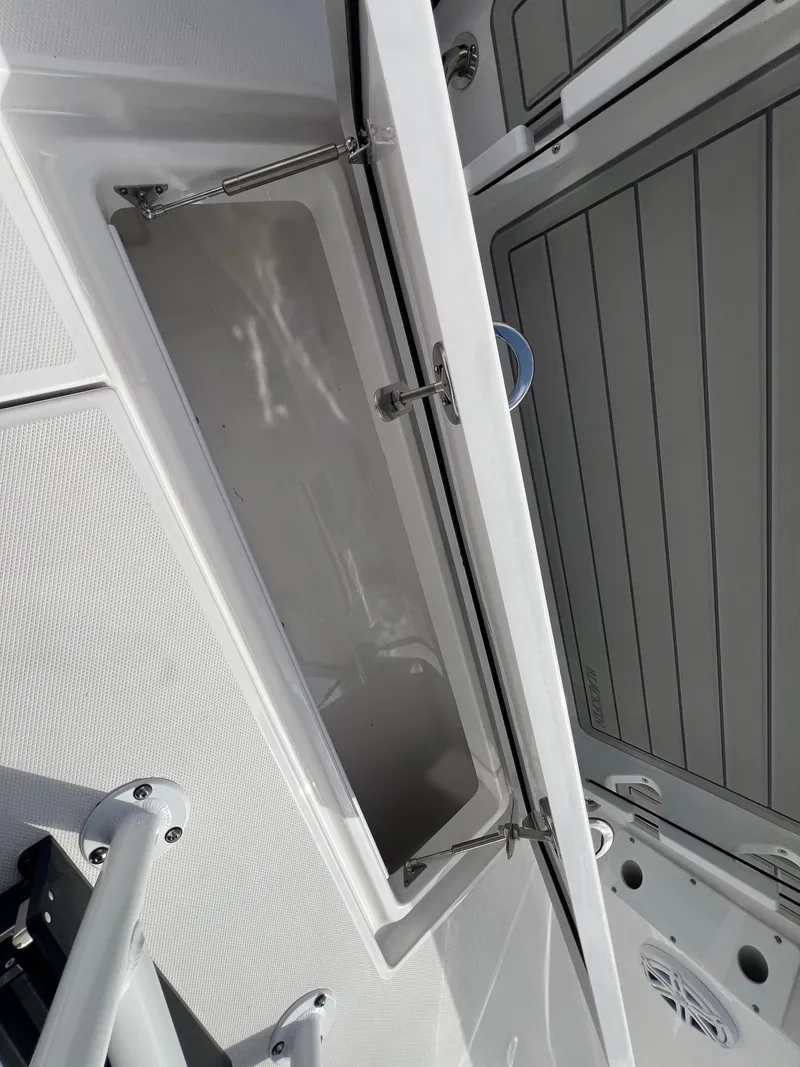 Slide: The Image of 2025 Blackfin 252 CC boat storage compartment with open hatch and sleek design. - 11
