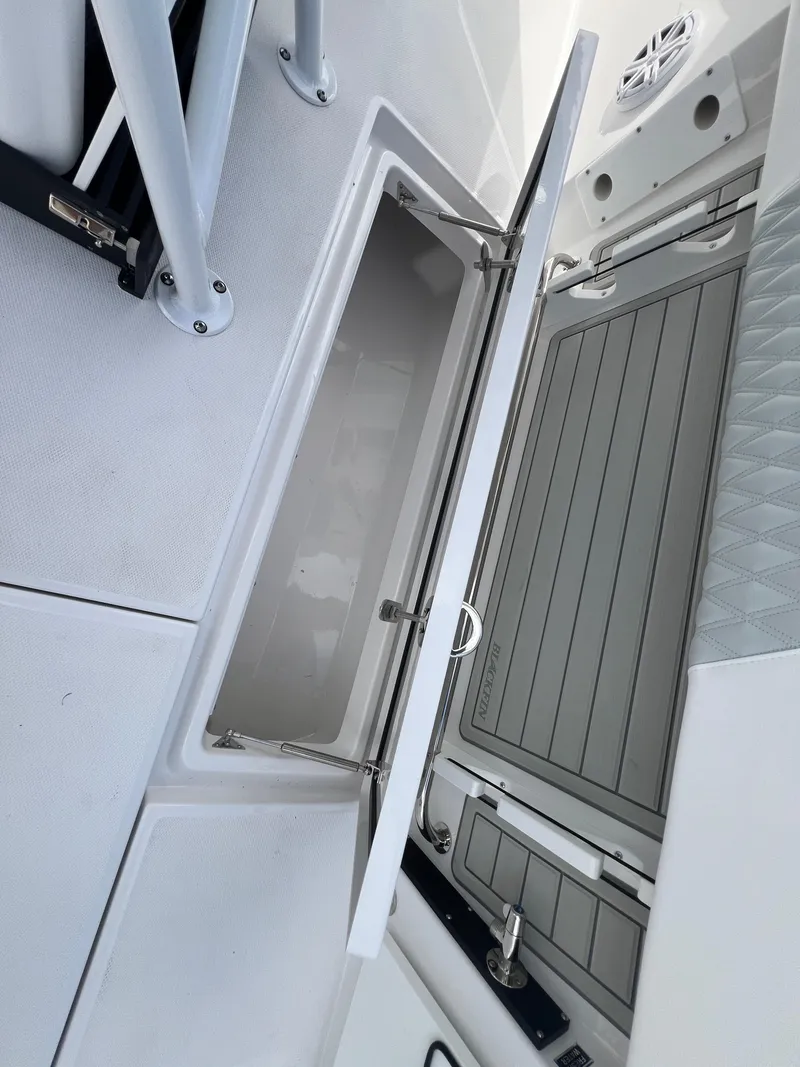 Slide: The Image of 2025 Blackfin 252 CC boat storage compartment with open hatch and sleek design. - 12