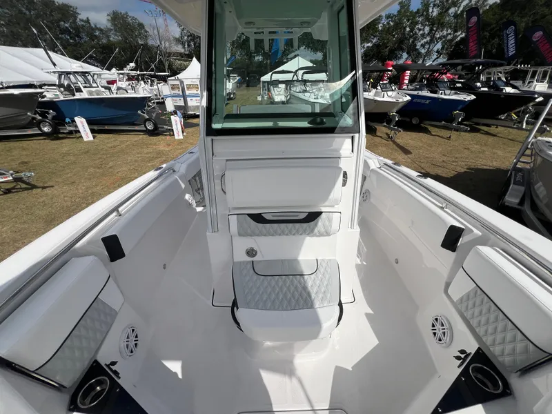 Slide: The Image of 2025 Blackfin 252 CC boat interior at outdoor boat show, showcasing seating and console design. - 22