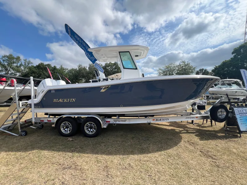 Slide: The Image of 2025 Blackfin 252 CC boat on trailer under cloudy sky at outdoor display. - 3