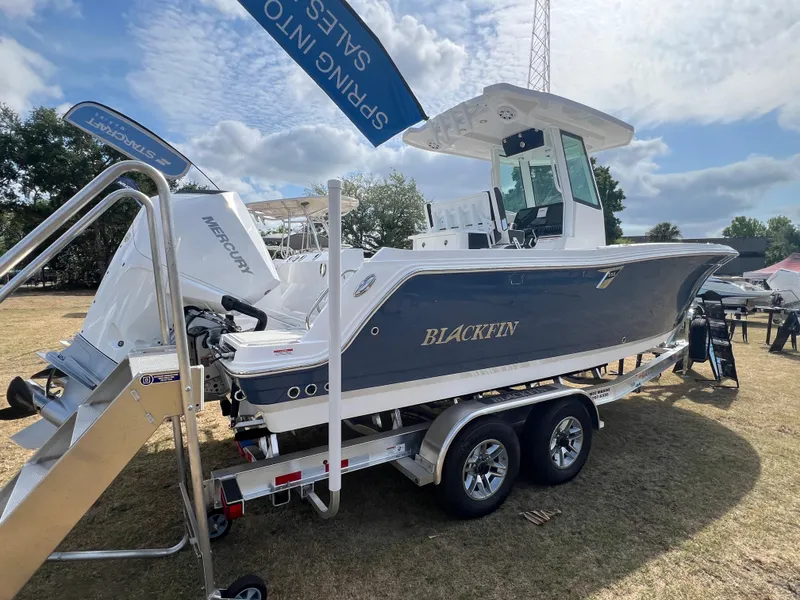 Slide: The Image of 2025 Blackfin 252 CC boat on trailer, displayed outdoors under a blue sky. - 4