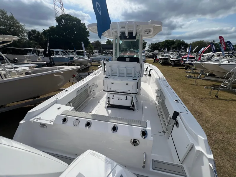 Slide: The Image of 2025 Blackfin 252 CC boat displayed outdoors, surrounded by other boats under a cloudy sky. - 7