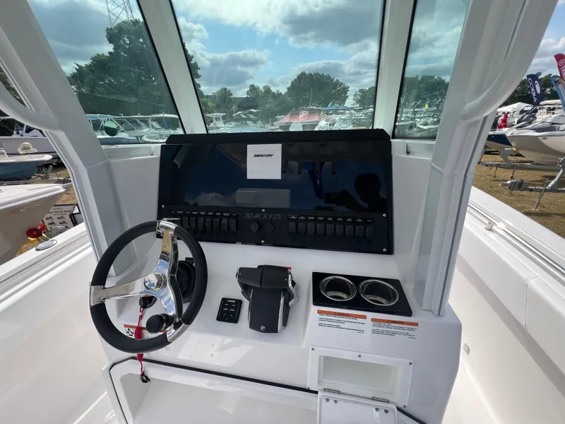 Slide: The Image of 2025 Blackfin 252 CC boat console with steering wheel and controls, outdoor setting. - 8