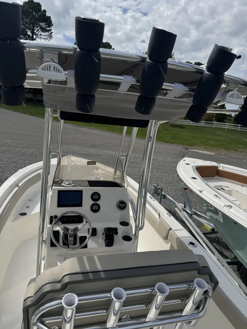 Slide: The Image of 2025 Key West 203 FS boat interior with steering console and rod holders. - 2