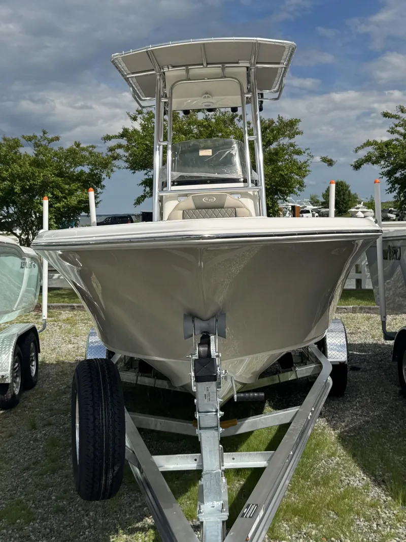 Slide: The Image of 2025 Key West 203 FS boat on trailer, parked outdoors under a partly cloudy sky. - 6