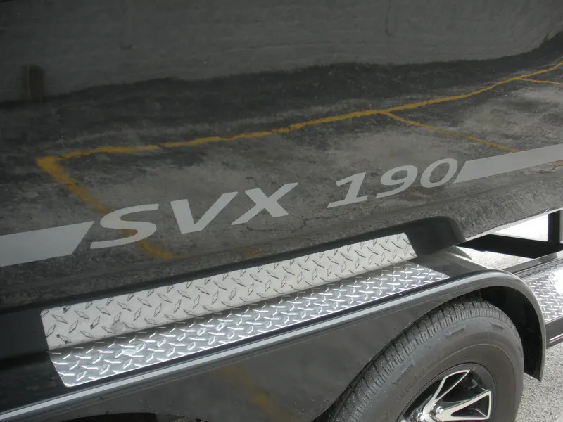 Slide: The Image of 2024 Starcraft SVX 190 OB DC boat with sleek black exterior and diamond plate detail. - 2