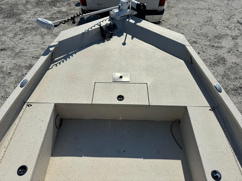 Slide: The Image of 2016 Alumacraft 2072 Bay boat interior with trolling motor on a sandy surface. - 10