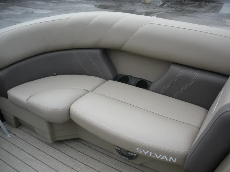 Slide: The Image of 2024 Sylvan Mirage 820 LZ boat seating with beige upholstery and cup holders. - 6