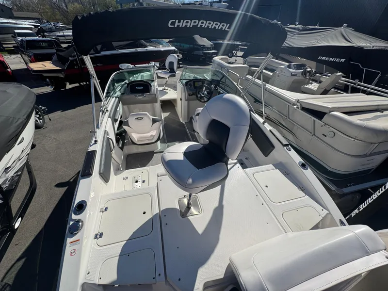 Slide: The Image of 2020 Chaparral 21 SSi Ski & Fish OB boat with seating and steering console, docked outdoors. - 21