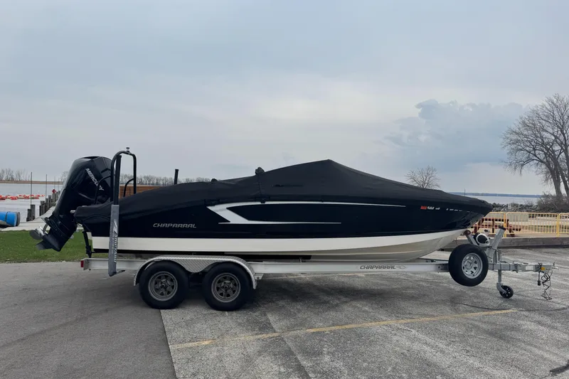 Slide: The Image of 2020 Chaparral 21 SSi Ski & Fish OB boat on trailer, covered, parked outdoors. - 22