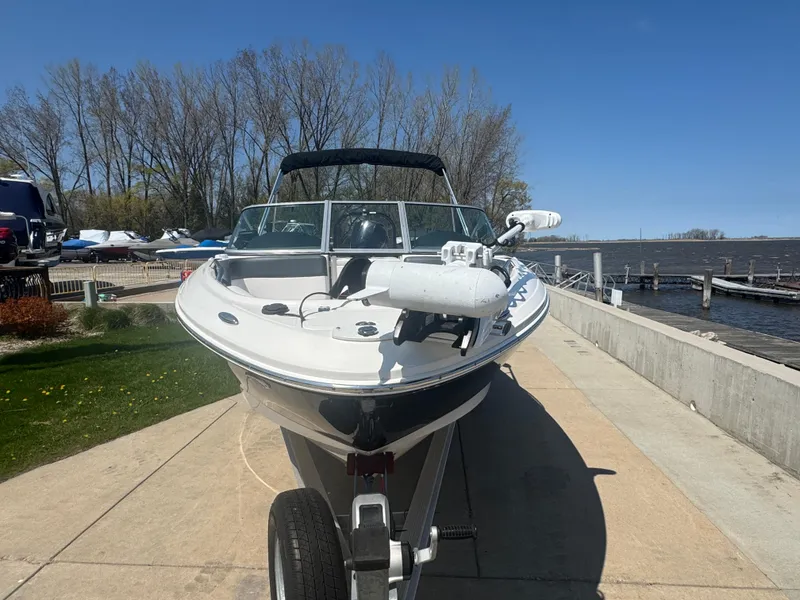 Slide: The Image of 2020 Chaparral 21 SSi Ski & Fish OB boat on trailer by lakeside dock. - 4