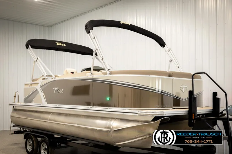 Slide: The Image of 2024 Tahoe 2185 LTZ QL pontoon boat on trailer in indoor showroom. - 2