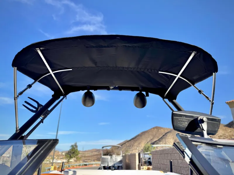 Slide: The Image of 2021 Axis T22 boat with black bimini top against clear blue sky. - 12