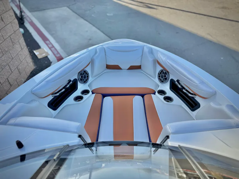 Slide: The Image of 2021 Axis T22 boat interior with brown and white seating, cup holders, and speakers. - 16