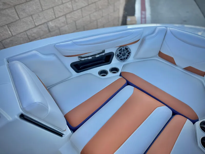 Slide: The Image of 2021 Axis T22 boat interior with white and orange seating, cup holders, and speaker. - 17