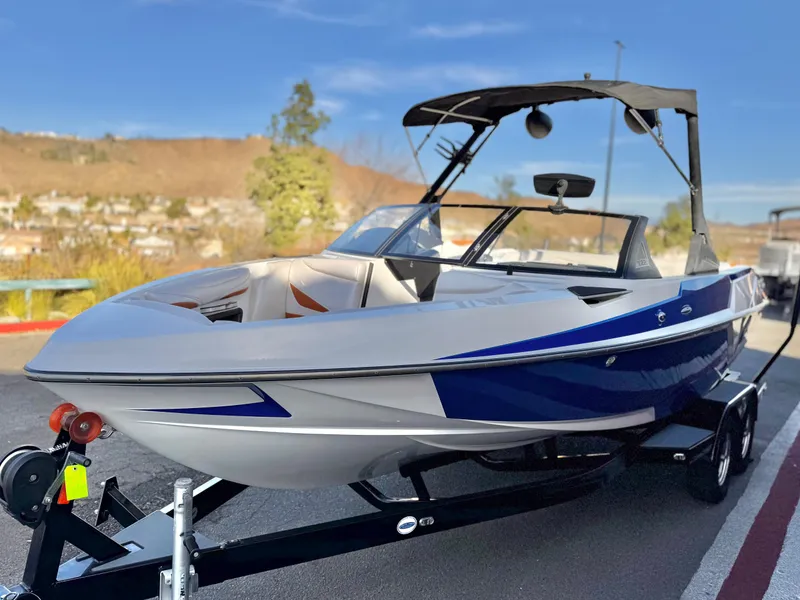 Slide: The Image of 2021 Axis T22 boat on trailer, blue and white design, parked outdoors. - 3