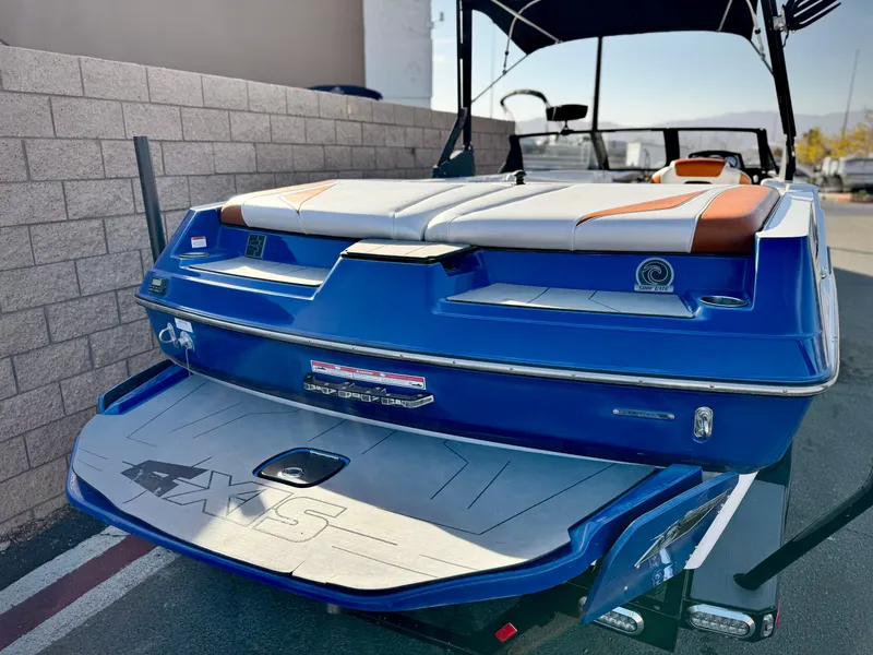 Slide: The Image of 2021 Axis T22 boat, blue exterior, rear view, parked on a street. - 8