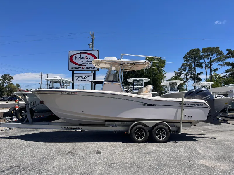 Slide: The Image of 2013 Grady-White Fisherman 257 boat on trailer, parked outdoors under clear blue sky. - 0