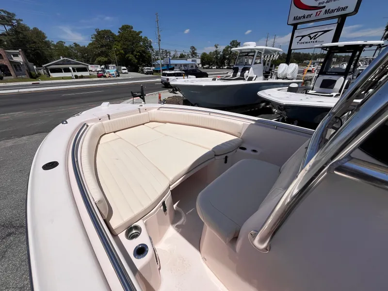 Slide: The Image of 2013 Grady-White Fisherman 257 boat with cushioned seating, displayed outdoors at a marine dealership. - 19