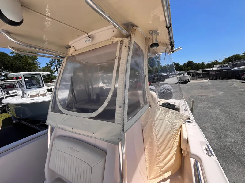 Slide: The Image of 2013 Grady-White Fisherman 257 boat with protective enclosure, parked outdoors under clear blue sky. - 29