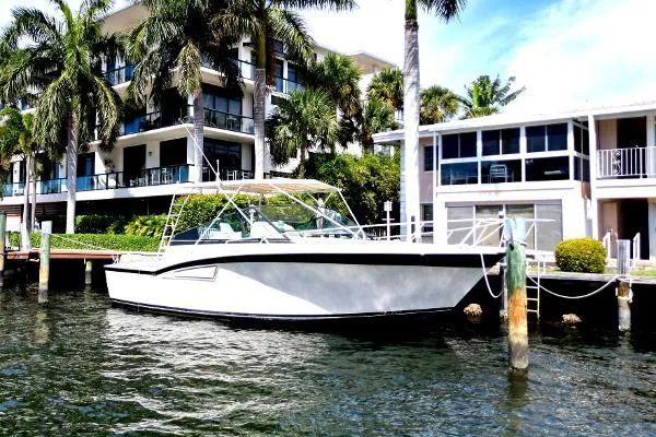 The Image of Atlantic 38 Super Sport 1991 boat docked by waterfront homes and palm trees. - 0