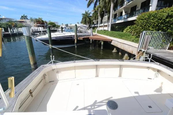 Slide: The Image of 1991 Atlantic 38 Super Sport docked at a marina with palm trees and waterfront buildings. - 2