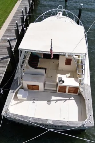 Slide: The Image of 1991 Atlantic 38 Super Sport boat docked, aerial view of spacious deck and seating area. - 6