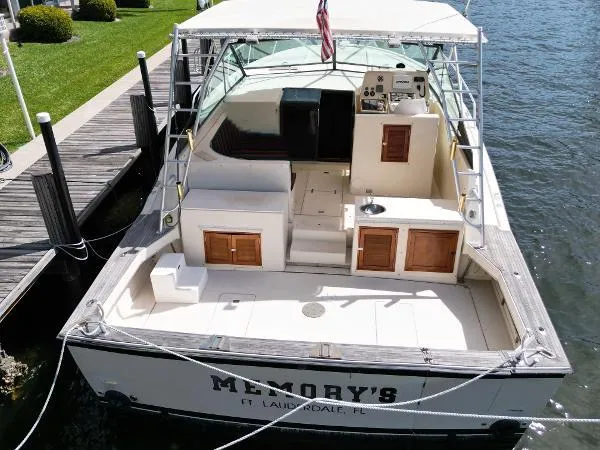 Slide: The Image of 1991 Atlantic 38 Super Sport boat docked, featuring spacious deck and cabin area. - 7