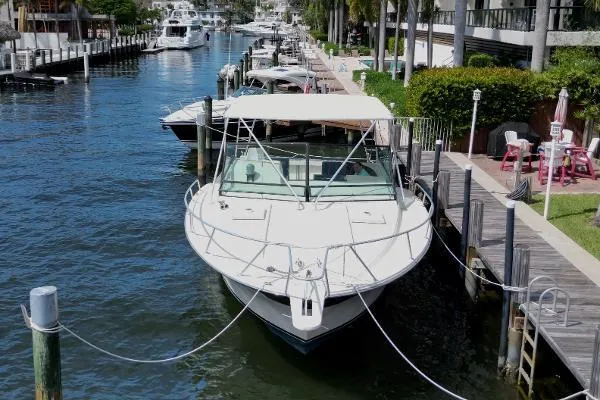 Slide: The Image of 1991 Atlantic 38 Super Sport yacht docked in a scenic marina setting. - 8