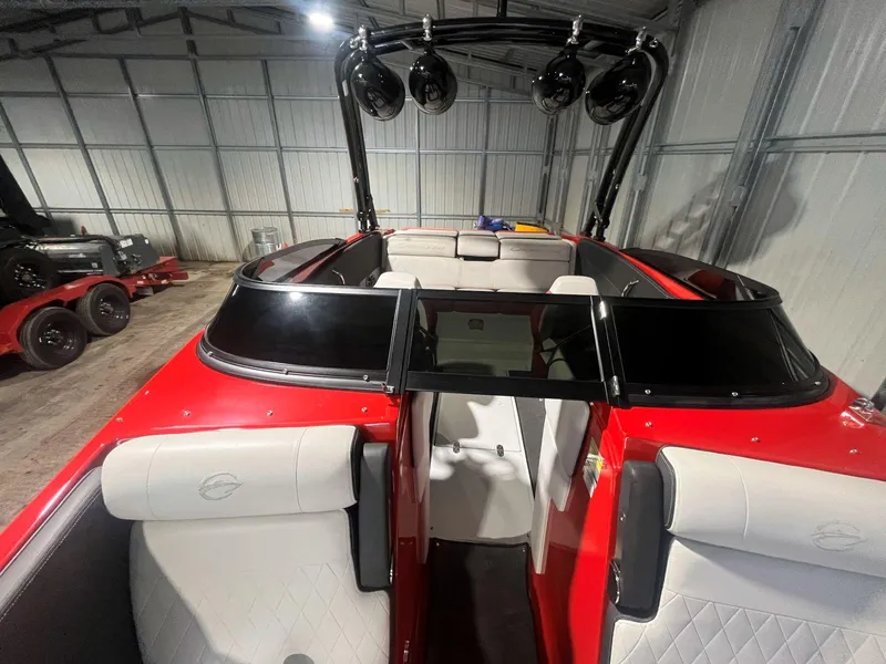 Slide: The Image of 2022 Crownline 240 SS LPX boat interior with red and white seating, stored indoors. - 11