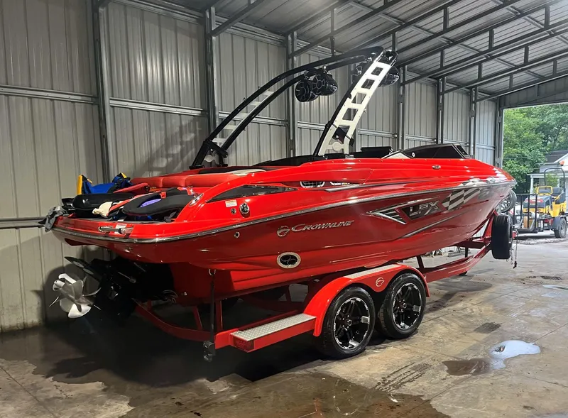Slide: The Image of Red 2022 Crownline 240 SS LPX boat on trailer in a metal garage. - 5