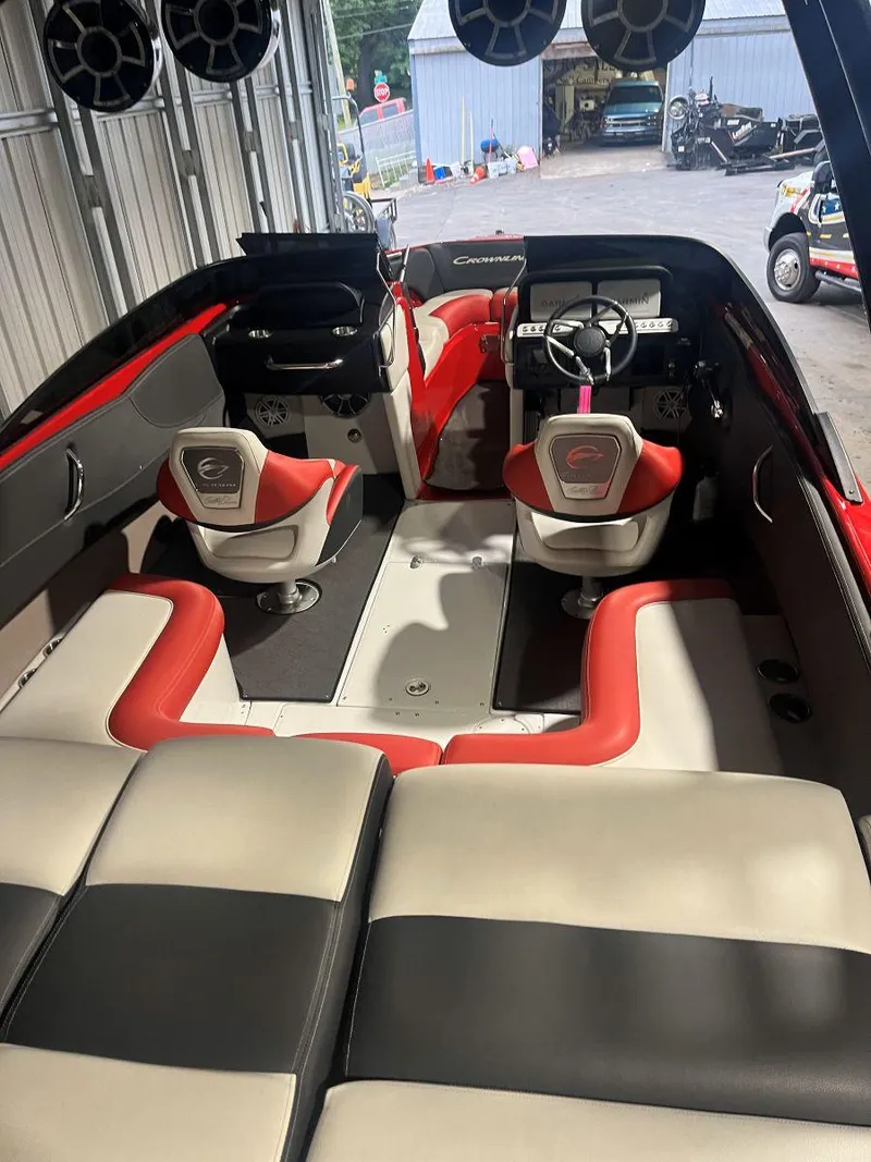 Slide: The Image of 2022 Crownline 240 SS LPX boat interior with red and white seating, modern dashboard, and speakers. - 6