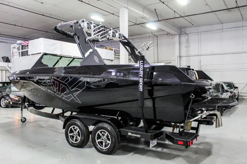 Slide: The Image of 2021 ATX Surf Boats 22 Type-S in showroom, sleek black design on trailer. - 2