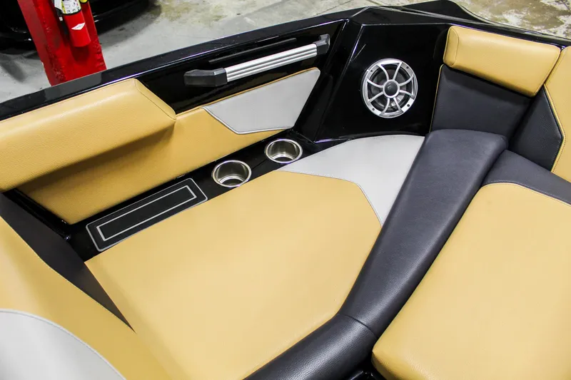 Slide: The Image of 2021 ATX Surf Boats 22 Type-S interior with tan and black seating, cup holders, and speaker. - 20