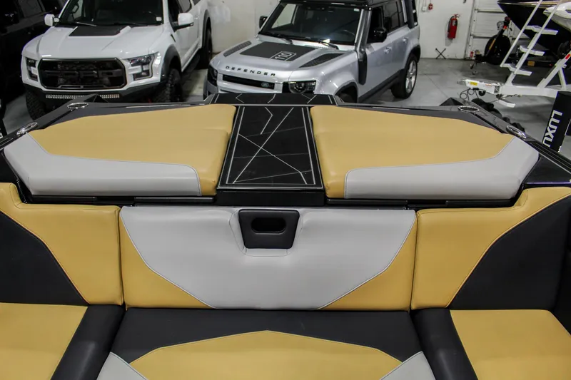 Slide: The Image of 2021 ATX Surf Boats 22 Type-S interior with tan and gray upholstery in a showroom. - 29