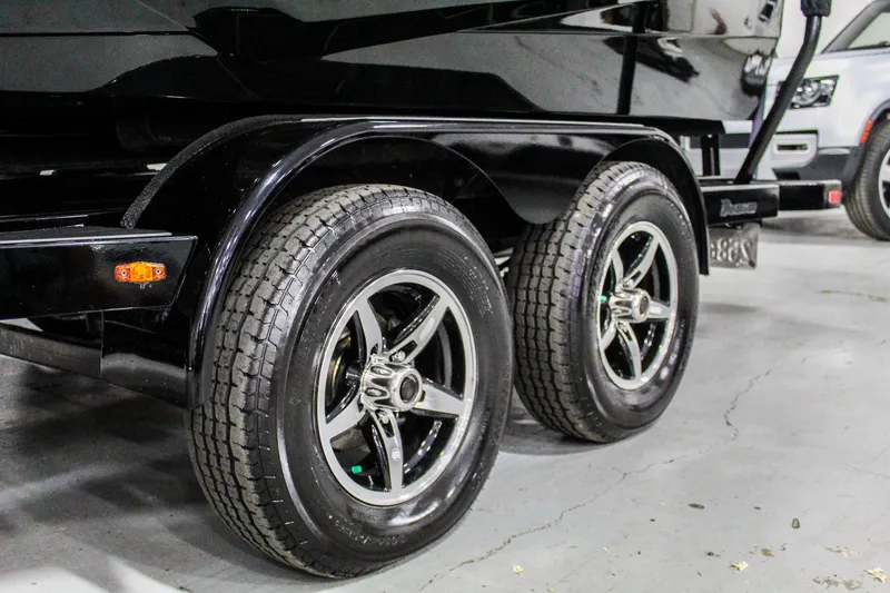 Slide: The Image of 2021 ATX Surf Boats 22 Type-S trailer with dual wheels in a garage setting. - 49