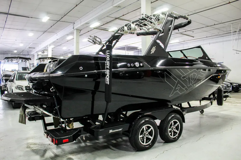 Slide: The Image of 2021 ATX Surf Boats 22 Type-S, sleek black design, displayed indoors on a trailer. - 5
