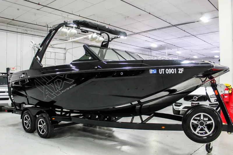 Slide: The Image of 2021 ATX Surf Boats 22 Type-S, sleek black design, on trailer in indoor showroom. - 6