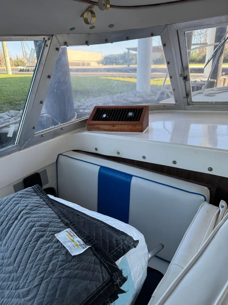 Slide: The Image of 1978 Bertram 31 Sportfisher Yanmars interior with blue and white seating, window view. - 10