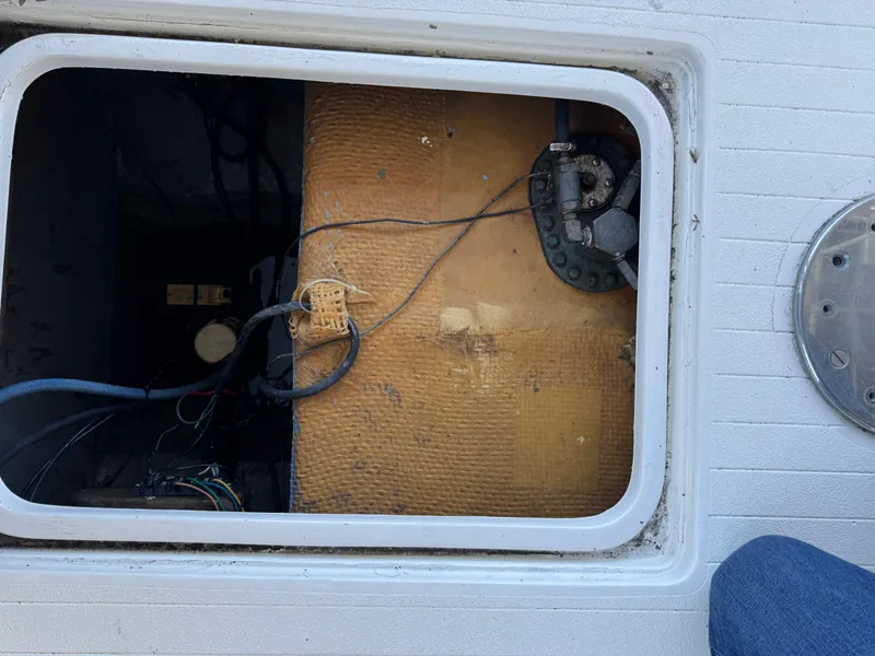 Slide: The Image of Open hatch of 1978 Bertram 31 Sportfisher Yanmars showing internal components and wiring. - 14