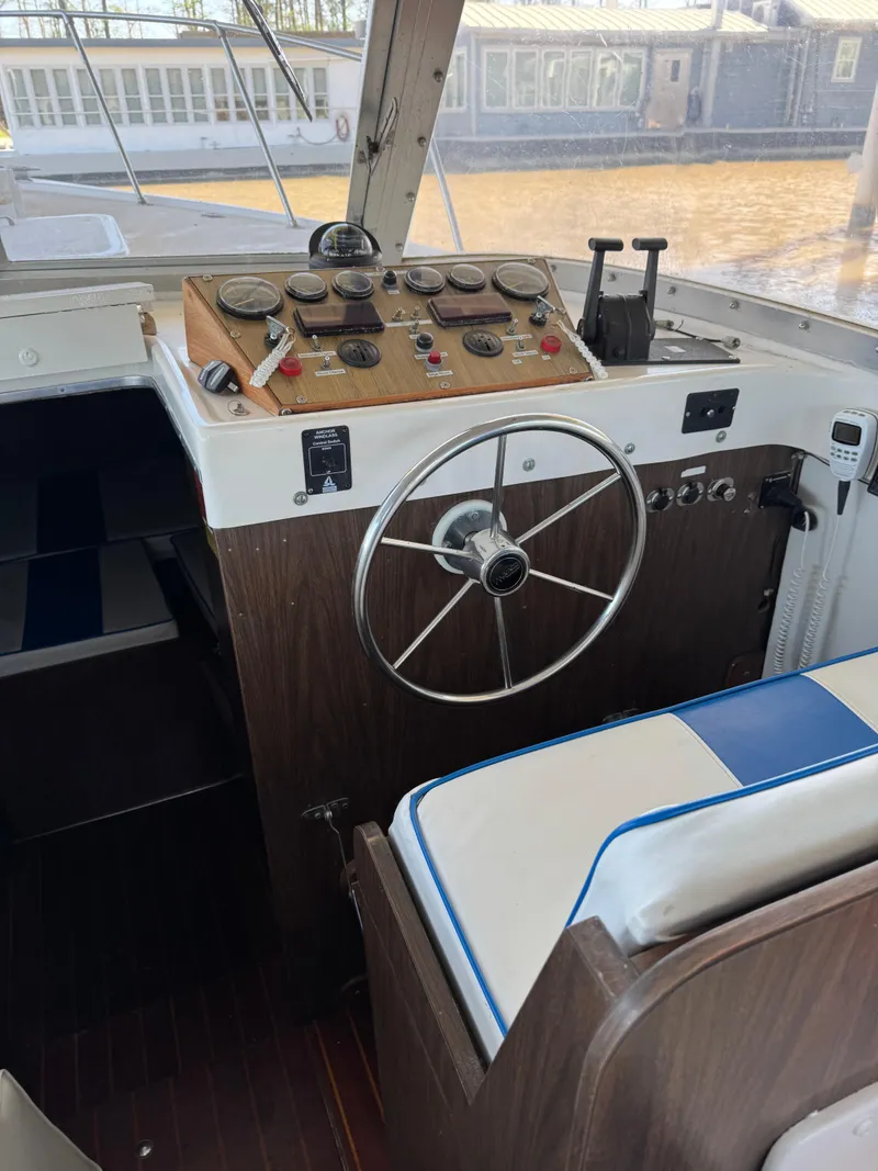 Slide: The Image of 1978 Bertram 31 Sportfisher Yanmars helm with classic controls and steering wheel. - 17
